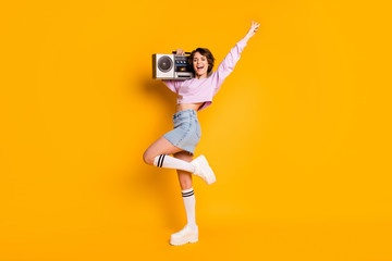 Full length body size view of her she nice attractive lovely cheerful funny girl carrying boombox having fun dancing retro vintage trend isolated on bright vivid shine vibrant yellow color background