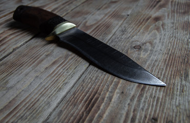 Close-up of a Damascus steel hunting knife on a wooden table