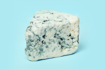 Blue cheese on blue background closeup