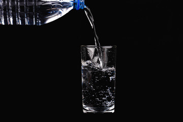 A glass of water on a black background. Close-up