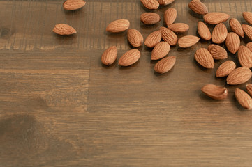 Almonds are scattered on a wooden background top view for texts entries notes menus