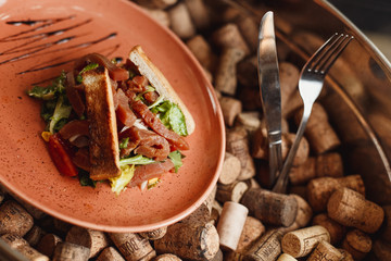 Salad with salmon, toast and mix Salad leaves on the background of wine corks