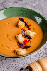 Spanish cuisine. Cold summer tomato soup gazpacho with croutons and basil.