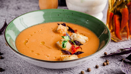 Spanish cuisine. Cold summer tomato soup gazpacho with croutons and basil.