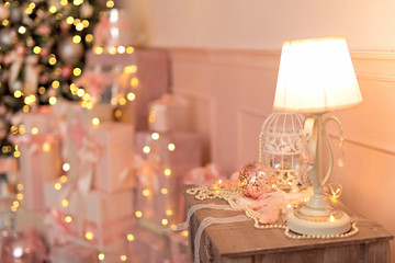 Beautiful festive decorated pink room with a Christmas tree with gifts under it.