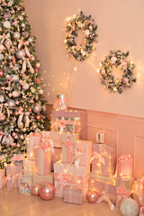 Beautiful festive decorated pink room with a Christmas tree with gifts under it.