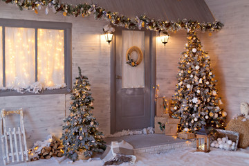 Christmas porch decorated in a New Year's style with a Christmas tree and garlands. Snowy Rozhdestvenskaya street.