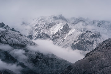 Obraz premium View of snow mountain surrounded by clouds with morning fog