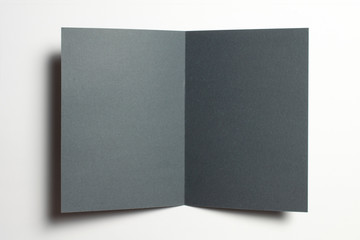 Blank black paper opened bi-fold flyer brochure isolated on white as template for design presentation, greeting cards, event promotion etc.