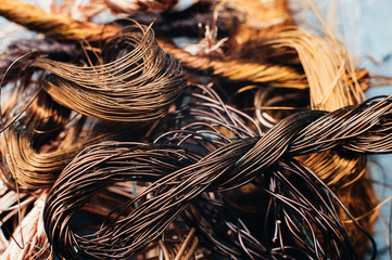 Copper scrap metal, wire, windings of motors and transformers, electrical wire without insulation. Against the background of a copper sheet. Close-up. Macro.