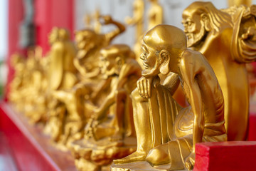 Fototapeta premium The statue of the golden Buddhist saint in the temple for people to pay respect