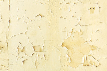 Abblätternde Farbe mit Rissen an einer Zimmerwand als Hintergrund
