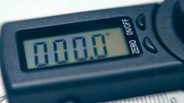 The modern device, which is very necessary in construction and repair - digital goniometer - measuring the angle of an inclined surface. Macro. Closeup