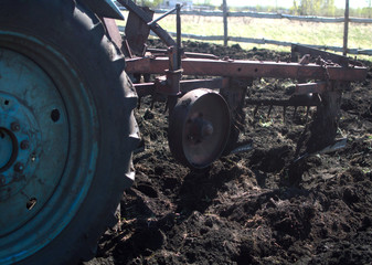 Tractor cultivates field in spring. Land cultivation.