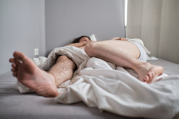 Obraz na płótnie Canvas Legs of a gay couple in bed