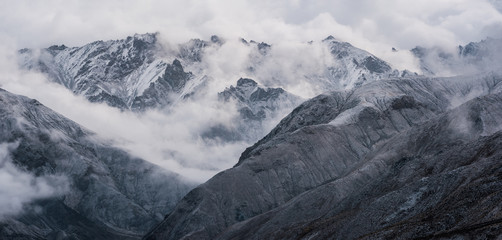 Fototapeta premium View of snow mountain surrounded by clouds with morning fog