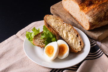 Healthy meal food concept homemade organic artisan sourdough bread and boiled egg in white plate with copy space