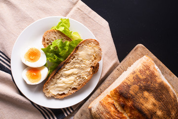 Healthy meal food concept homemade organic artisan sourdough bread and boiled egg in white plate with copy space