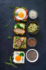 Different sandwiches on a black background. Tasty healthy appetizer with avocado. Quick breakfasts. Healthy eating concept. Proper nutrition. Top view