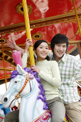 Man and woman riding on carousel