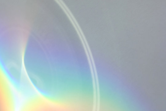 Blurred Rainbow Circular Light Refraction Texture Overlay Effect For Photo And Mockups. Organic Drop Diagonal Holographic Flare On A White Wall. Shadows For Natural Light Effects