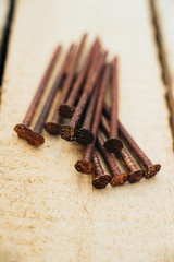 Scrap copper, old copper dirty oxidized nails. Against the background of an untreated wooden board. Close-up. Macro.