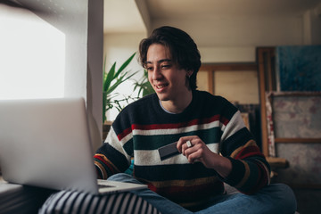 man using laptop for online paying from his home