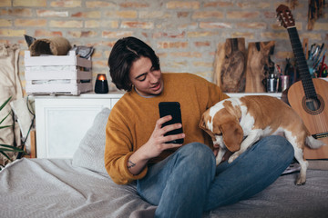 young man playing with his dog at home