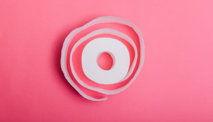 Conceptual image of toilet paper roll standing alone at pastel background. Roll of toilet paper on a pastel pink background. Coronavirus covid-19 design.