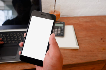 The cropped shot view of The asian woman works on the wood desk with the mobile phone,note book,and claculator with blank copy space screen for  information content or text message.for work from home.