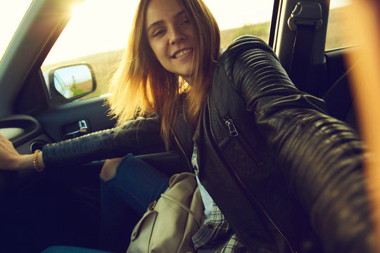 A girl making selfie portrait in the car with view