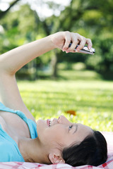 Naklejka premium Woman lying down while looking at her mobile phone