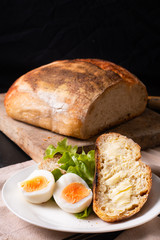 Healthy meal food concept homemade organic artisan sourdough bread and boiled egg in white plate with copy space