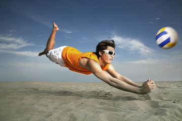 Man diving to hit volleyball