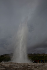 Geyser erupting on Geysir geothermal field in central Iceland. A waterspout flies up to the sky for about 30 meters and immediately drops