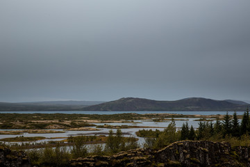 Landscape near the Mývatn lake in the north of Iceland. The sky is grey and there are many water points visible in the distance