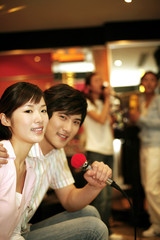 Man and woman singing together in karaoke bar