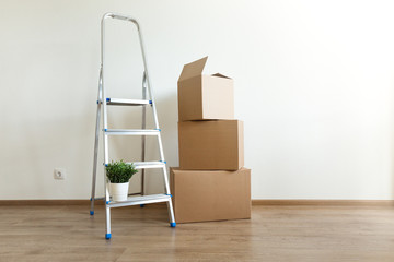 Carton boxes and ladder in new house, closeup