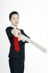 Businesswoman practising martial arts with a sword