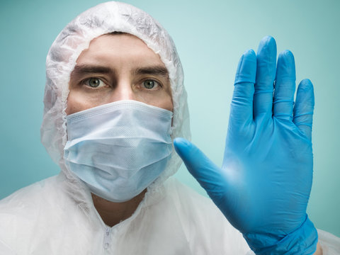 Man in protective suit and medical mask on blue background