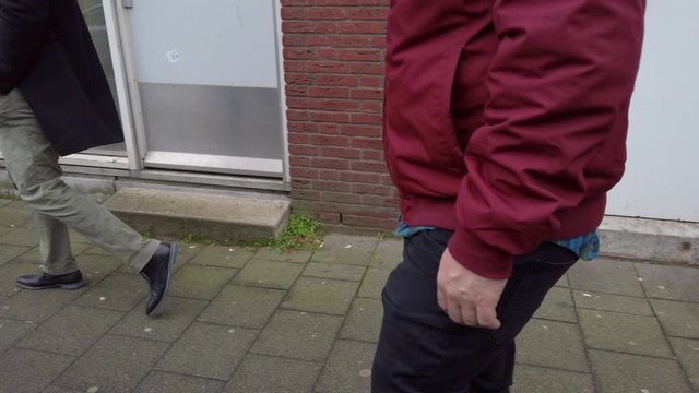 Tourist walking down european sidwalk next to brick buildings - side profile