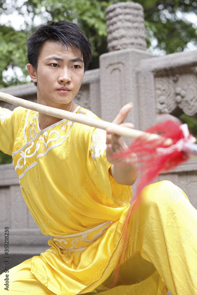 Wall mural man practising martial arts with chinese spear