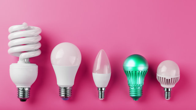 A special Light bulb stands out from the group of ordinary white light bulbs on a pink background.