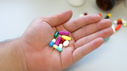 Obesity patient take medicine colorful tablets, pills and capsules in hand for treatment and cure disease or sickness. Drug prescription use for medication in medical clinic, pharmacy service concept.