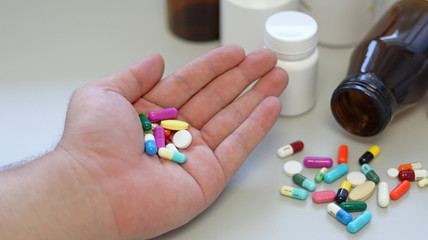 Obesity patient take medicine colorful tablets, pills and capsules in hand for treatment and cure disease or sickness. Drug prescription use for medication in medical clinic, pharmacy service concept.