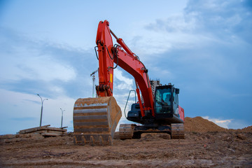 Excavator working at construction site on earthworks. Backhoe digging building foundation. Paving...