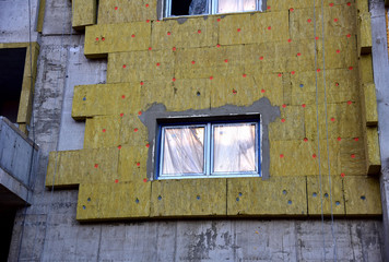 Mineral wool insulation of the facade building on construction site. Thermal protection of house....