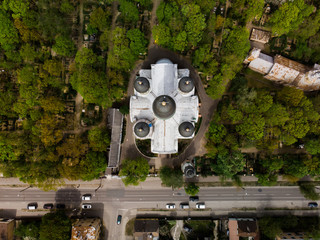 Top view of white orthodox church among green trees