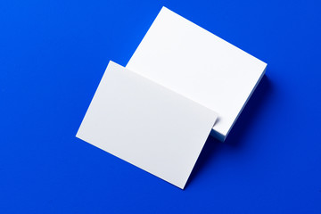 Blank white businesscards on classic blue background