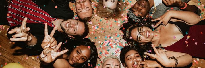 Friends lying on the floor at a party with balloons